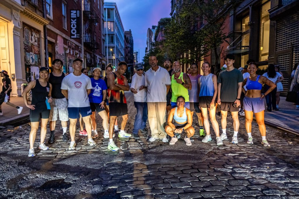 Bridge Runners crew on a cobblestone street in lower Manhattan at dusk
