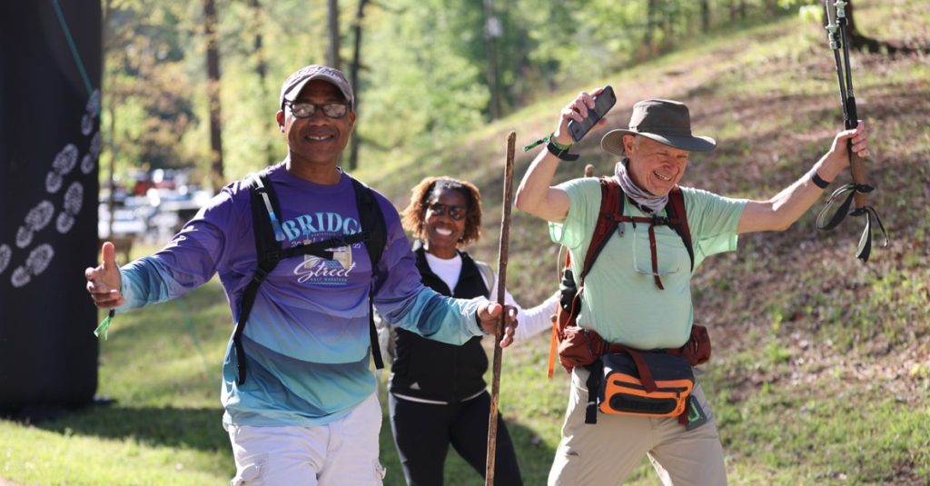 Hikers with backpacks and trekking poles on a trail at Mammoth March Boston