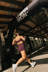 Urban Iron runner passing under the branded race arch
