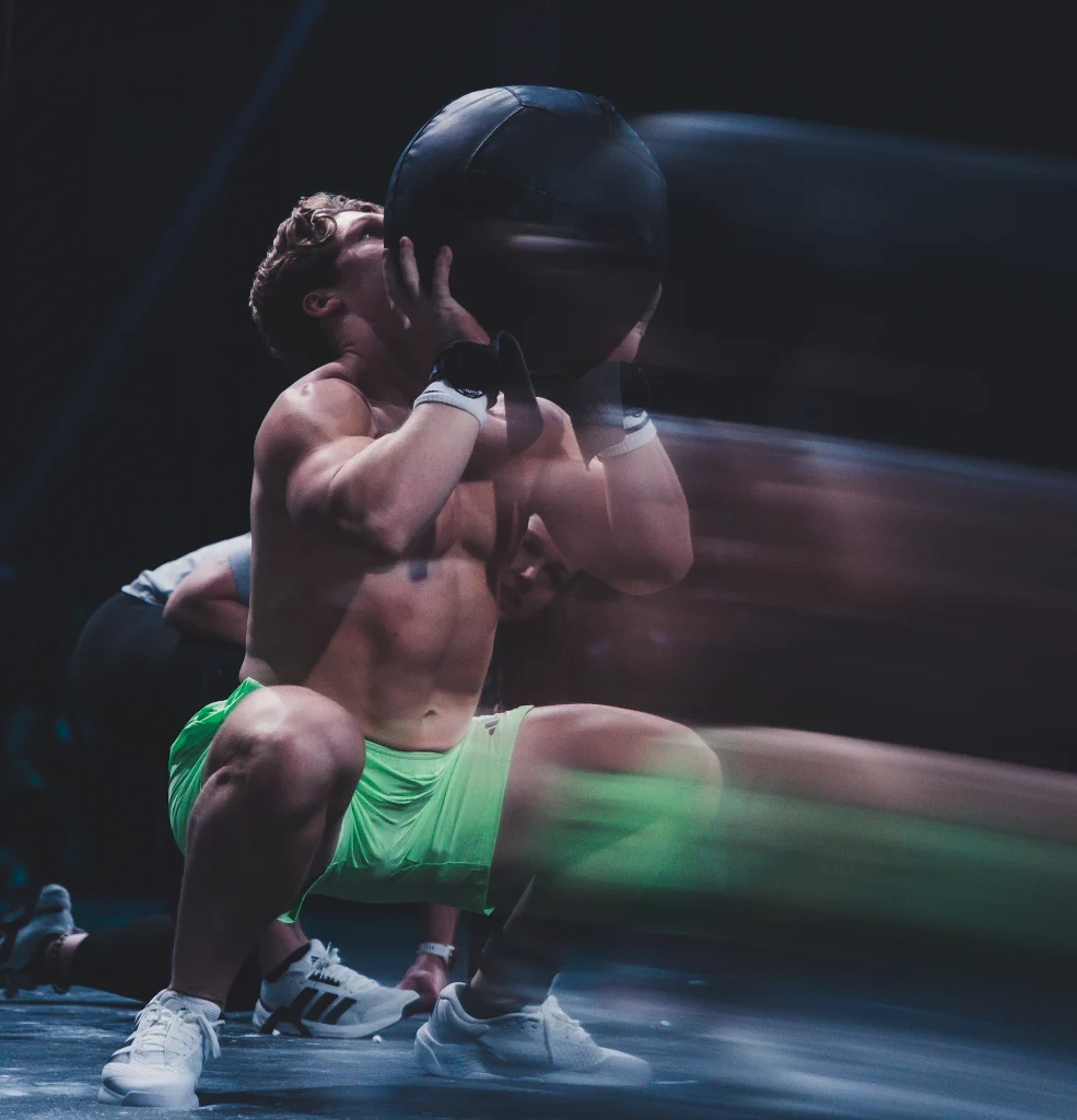 A World Fitness Project athlete performing wall ball reps on the competition floor