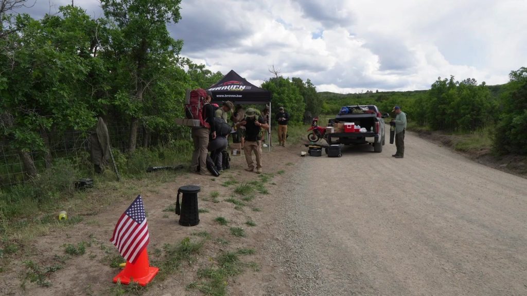 Competitors with multi-day packs at a trailside checkpoint in the Colorado backcountry during the Ryan Larkin Invitational Adventure Race