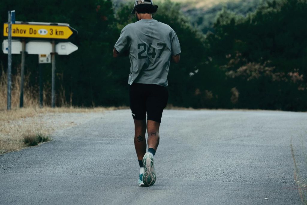 A runner in a 247 tee running along a quiet road