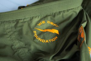 Close-up of the We Defy Foundation logo embroidered on a jiu-jitsu gi